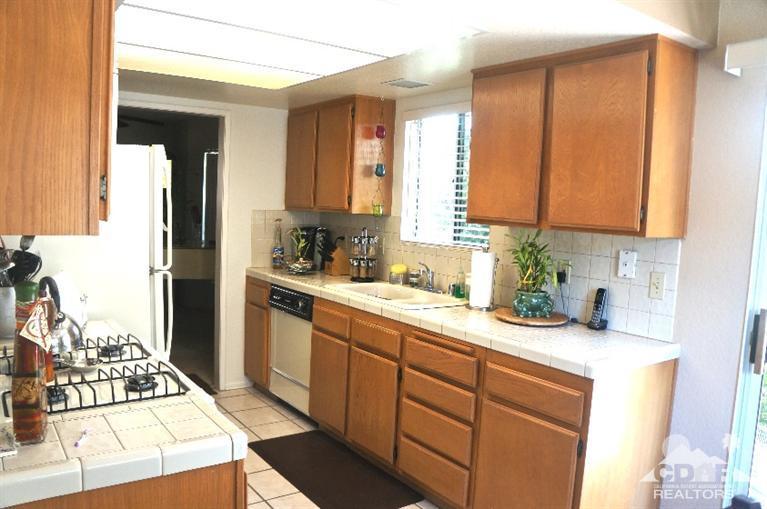 80928 Rio Grande Avenue Indio, CA 92201 - Photo 6 of 25 a kitchen with a sink a stove cabinets and a window