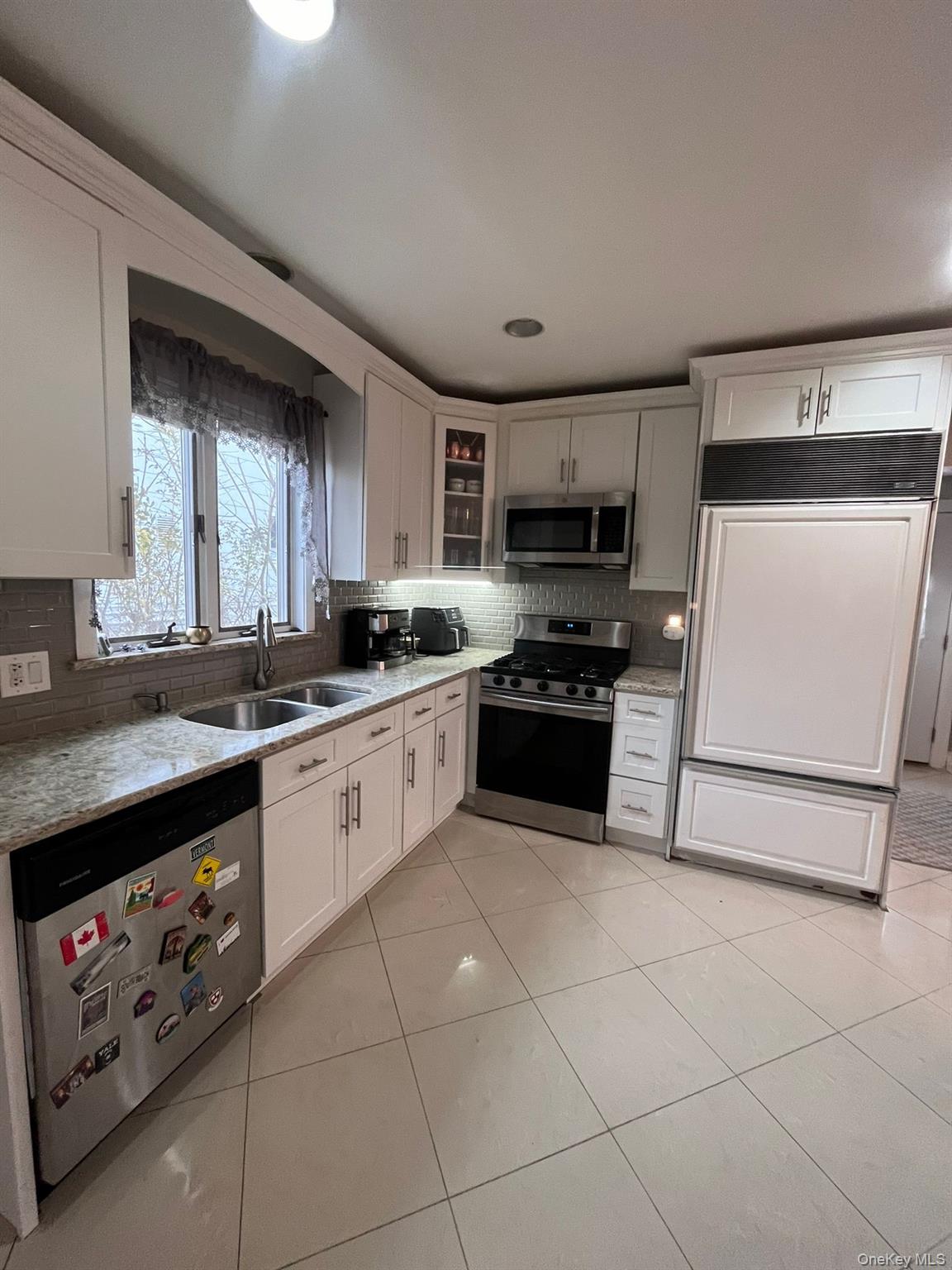 14 Redbrook Road Great Neck, NY 11024 - Photo 2 of 20 a large white kitchen with a stove a sink a microwave and cabinets