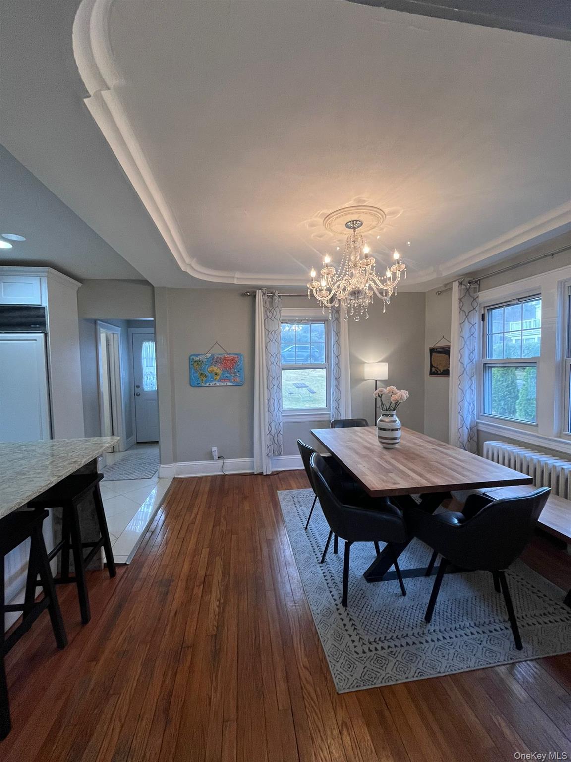 14 Redbrook Road Great Neck, NY 11024 - Photo 6 of 20 a dining room with wooden floor a chandelier a wooden table and chairs