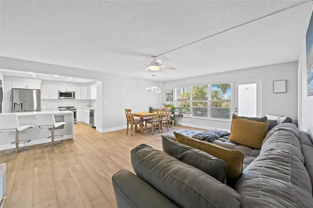 a living room with furniture and view of kitchen