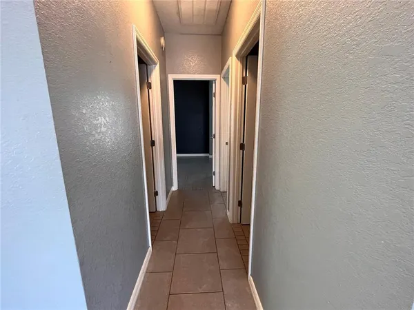 a view of a hallway with wooden shelves