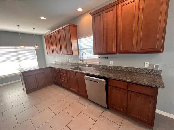 a kitchen with stainless steel appliances granite countertop wooden cabinets a sink and dishwasher