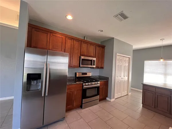 a kitchen with stainless steel appliances granite countertop a refrigerator and a sink