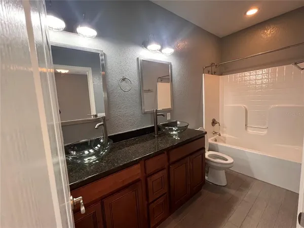 a bathroom with a double vanity sink toilet a mirror and shower