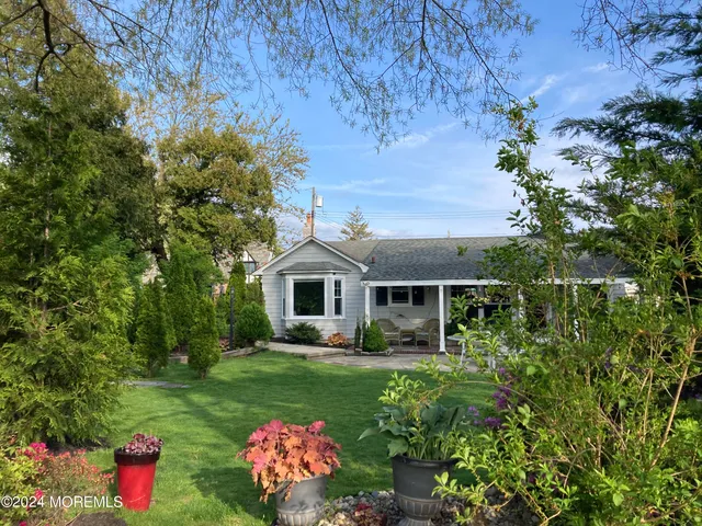 a front view of a house with a yard and fountain in middle