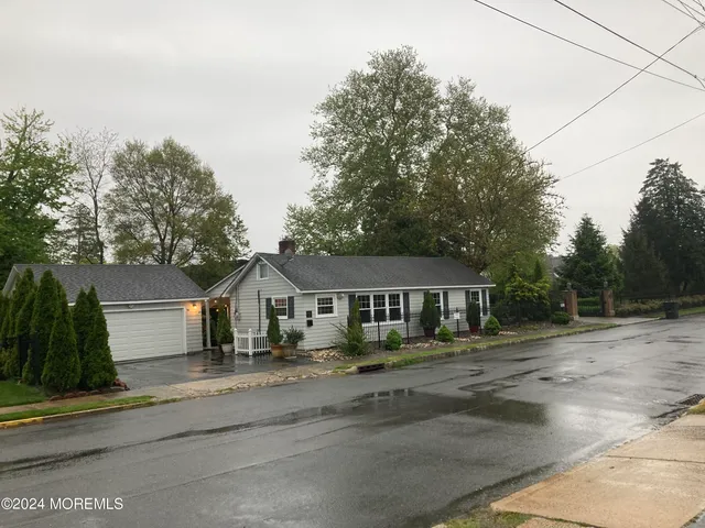 a front view of a house with a yard and trees