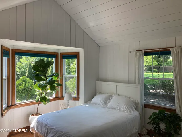 a bedroom with a bed and a large window