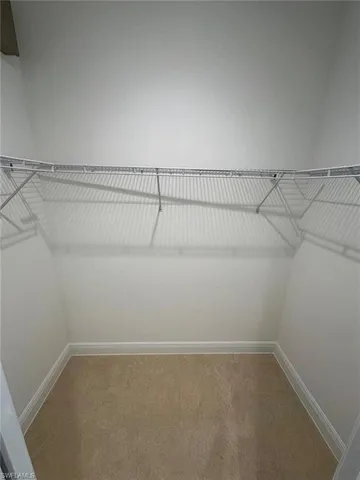 a view of a hallway to a livingroom with furniture