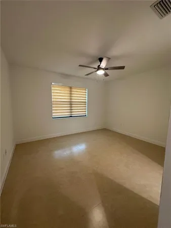 an empty room with windows and fan