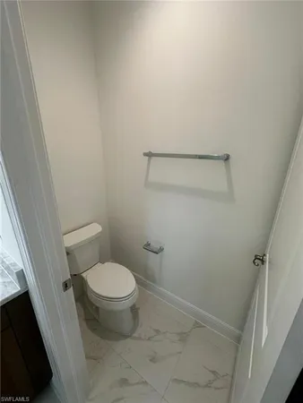 a white toilet sitting next to a shower