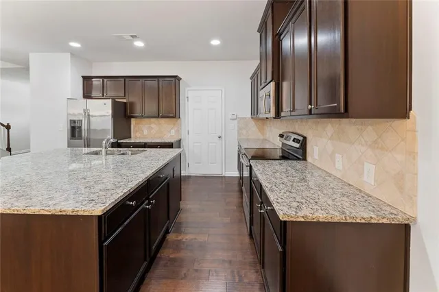 a kitchen with stainless steel appliances granite countertop granite counter tops refrigerator and stove