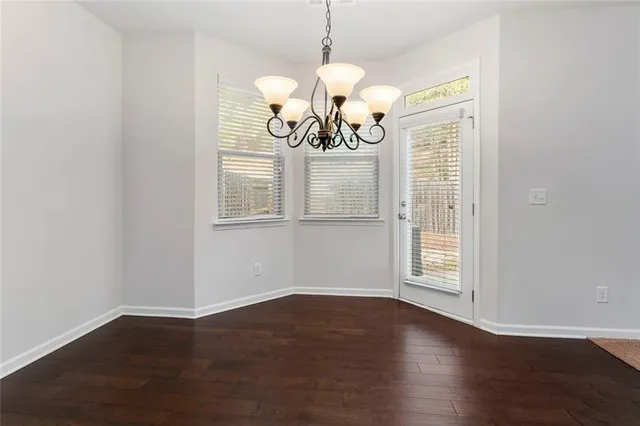 a view of a room with wooden floor and chandelier