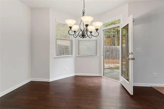 a view of a room with wooden floor and chandelier