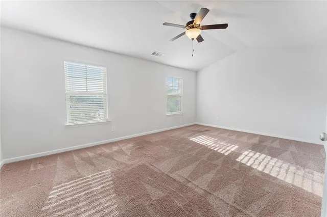 a view of a big room with a ceiling fan and a window