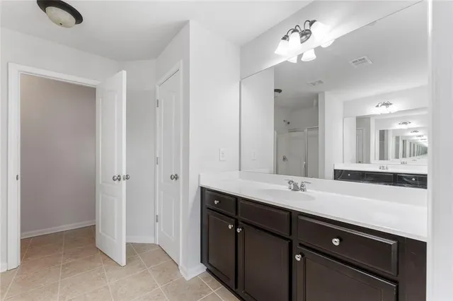 a bathroom with double vanity sinks a vanity a lamp and a mirror
