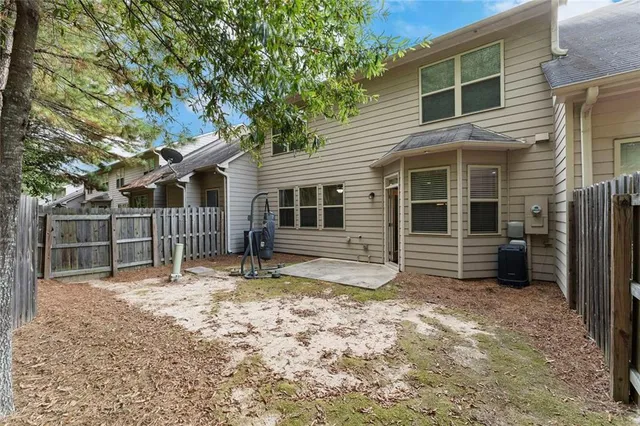 a view of a house with a yard and wooden fence