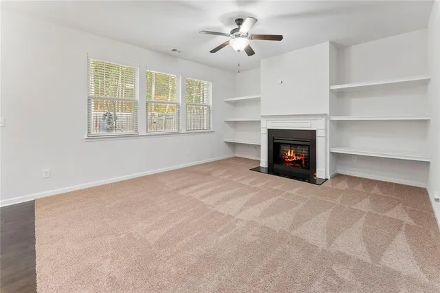 a view of an empty room with a fireplace and a window