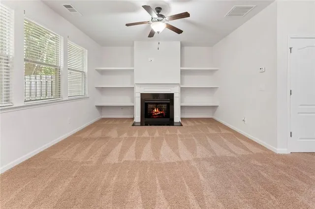 a view of an empty room with a fireplace and a window
