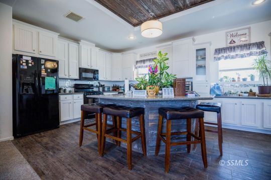 1577 North Calvert Boulevard Ridgecrest, CA 93555 - Photo 17 of 35 a kitchen with granite countertop stainless steel appliances a dining table and chairs