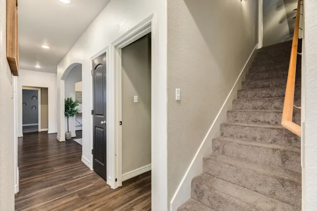 a view of a hallway with wooden floor and staircase