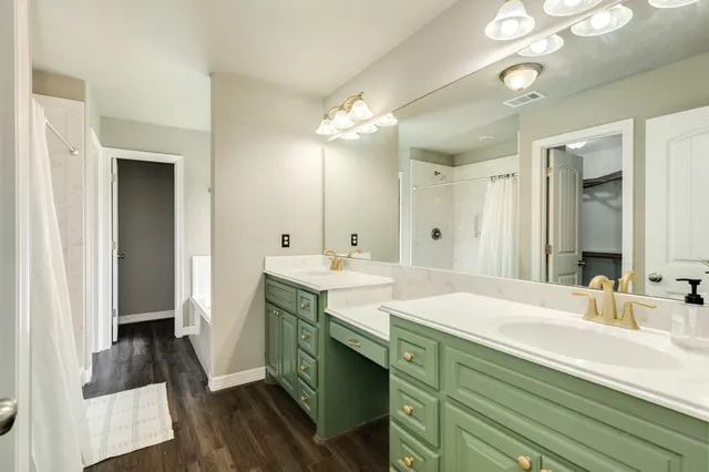 a spacious bathroom with a double vanity sink a mirror and a shower
