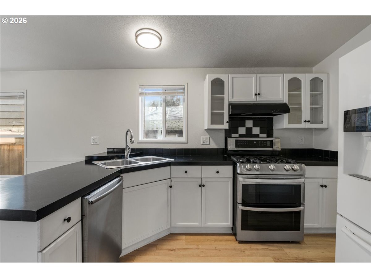 365 Southwest 7th Avenue Mill City, OR 97360 - Photo 10 of 43 a kitchen with stainless steel appliances a stove a sink and a microwave