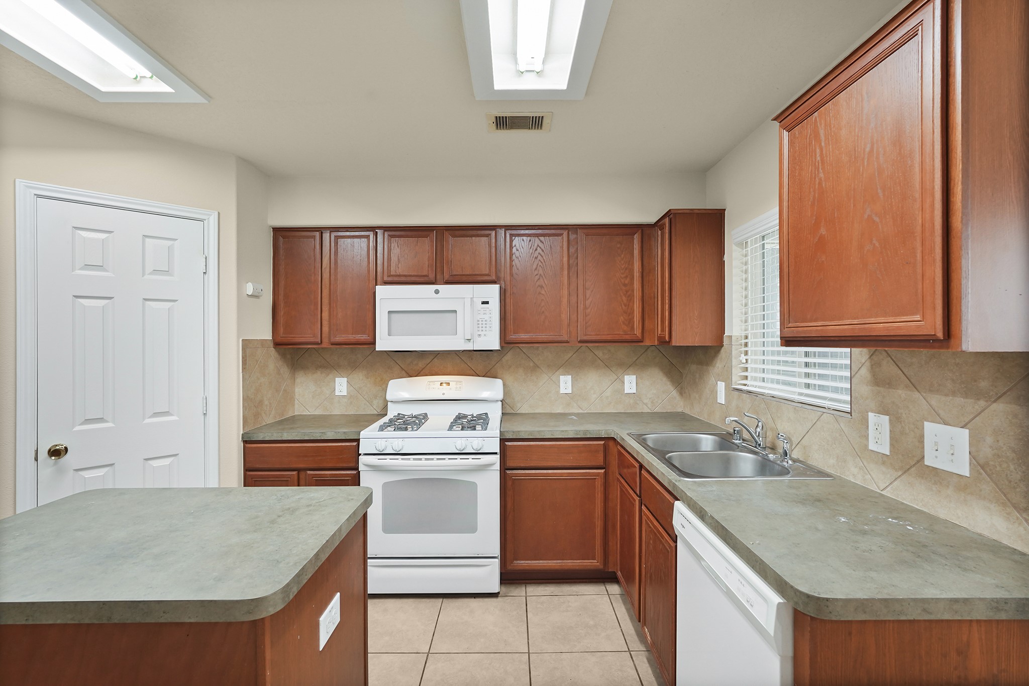 29417 Forest Floor Lane Spring, TX 77386 - Photo 10 of 25 a kitchen with a stove sink and cabinets