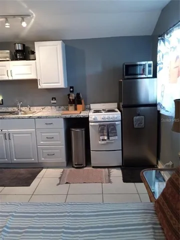 a kitchen with a stove refrigerator and sink