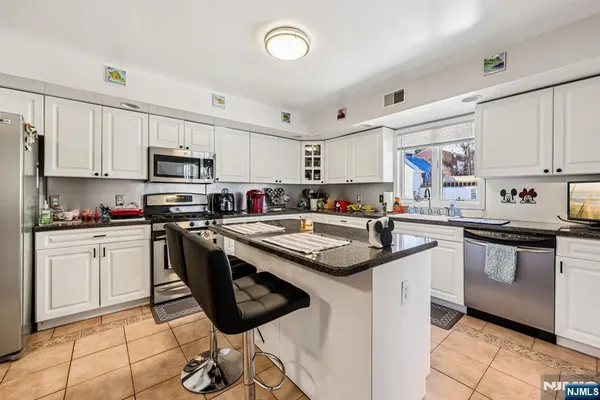 a kitchen with stainless steel appliances granite countertop a sink and cabinets