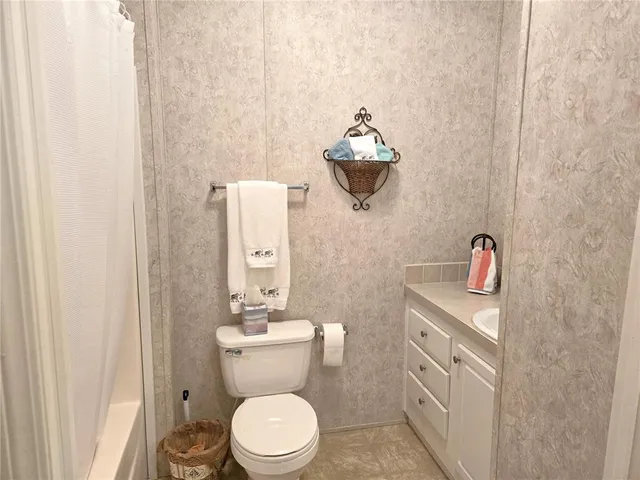 a bathroom with a granite countertop toilet and a shower