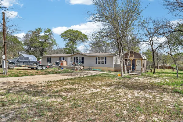 a front view of a house with a yard and trees