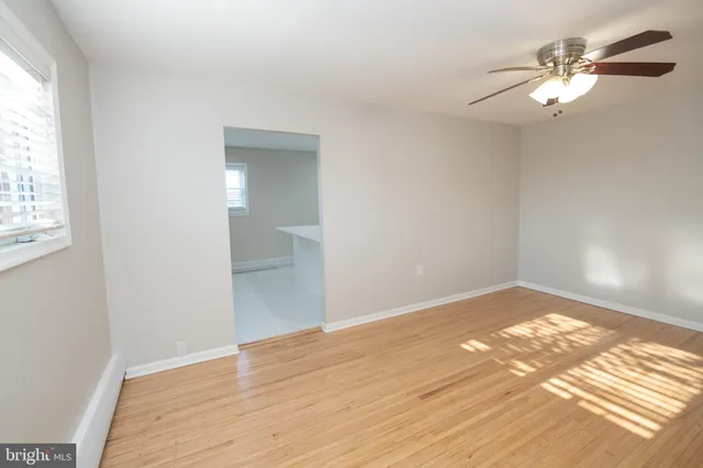 a view of a big room with wooden floor and windows