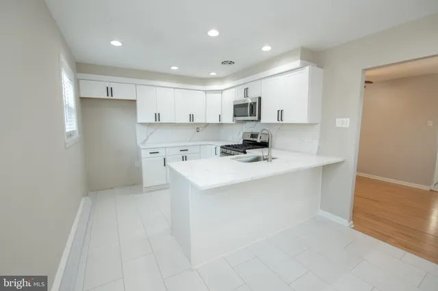 a kitchen with white cabinets appliances and a sink