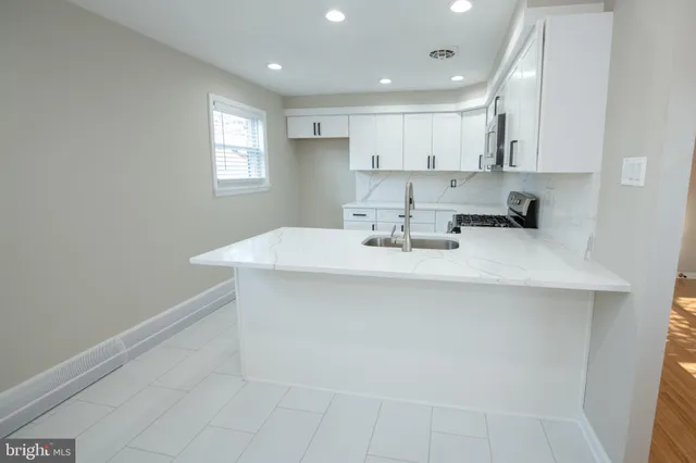 a kitchen with stainless steel appliances a sink stove and cabinets