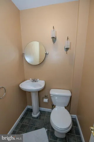 a bathroom with a toilet a sink and a mirror