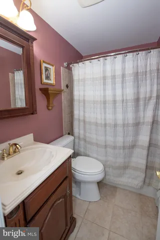 a view of an empty room with wooden floor and a ceiling fan