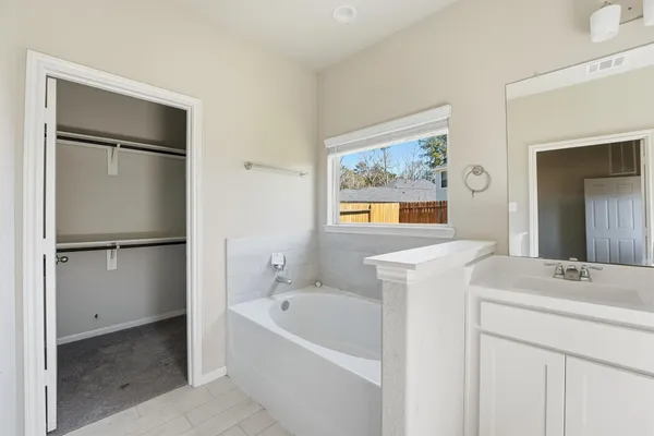 a bathroom with a sink a bathtub and a mirror