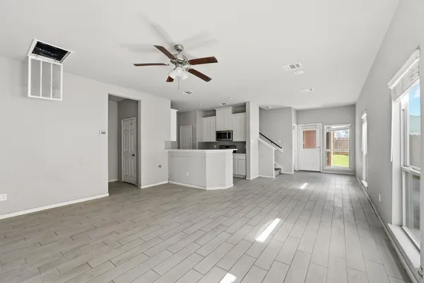 a view of a kitchen with wooden floor and a window
