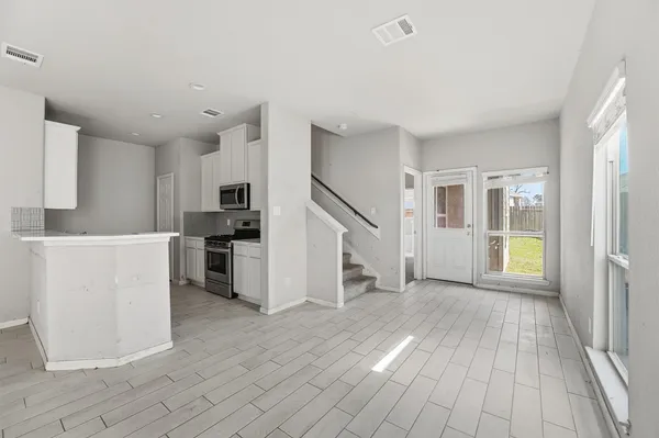 a view of a kitchen with wooden floor and electronic appliances