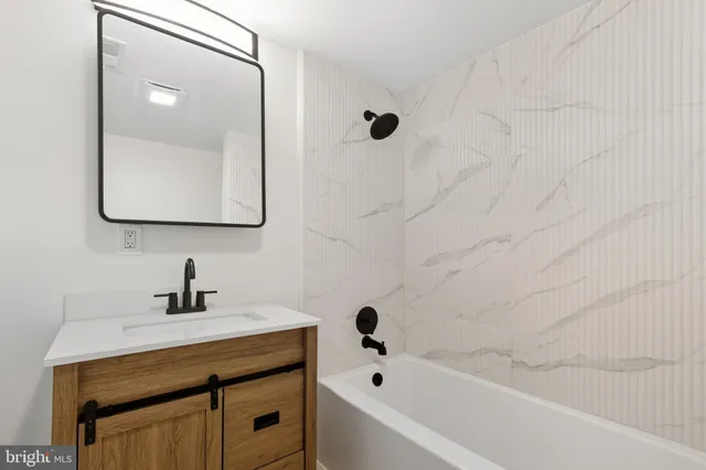 a bathroom with a tub sink and mirror