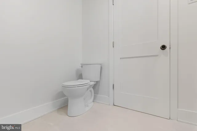 a white toilet sitting next to a shower