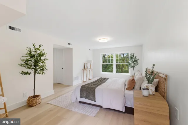 a bedroom with a bed and a potted plant