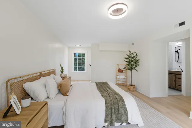 a bedroom with a bed and a potted plant
