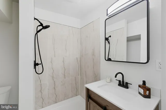 a bathroom with a shower sink and mirror