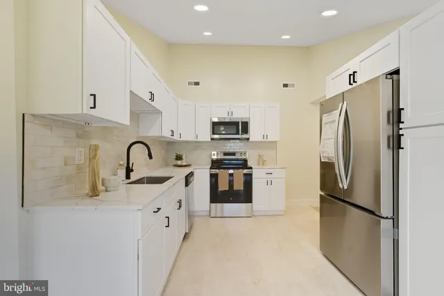 a kitchen with stainless steel appliances a refrigerator sink and microwave