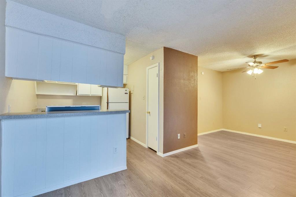400 West 34th Street, Unit 102 Austin, TX 78705 - Photo 10 of 10 Kitchen with a textured ceiling, a ceiling fan, freestanding refrigerator, light wood-style flooring, and open floor plan