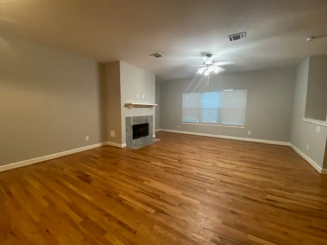 a view of an empty room with a fireplace and a window