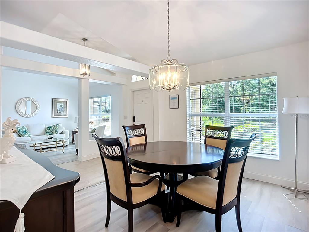 123 Marker Road Rotonda West, FL 33947 - Photo 14 of 66 a view of a dining room and livingroom with furniture wooden floor and a chandelier