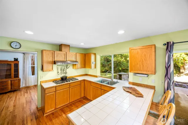 a large kitchen with stainless steel appliances a large window and a counter space