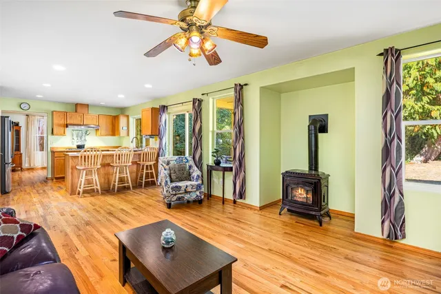 a living room with stainless steel appliances kitchen island granite countertop furniture and a flat screen tv